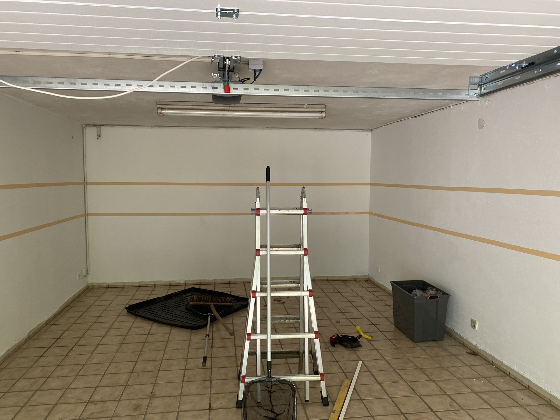 Leere Garage in Bad Oeynhausen mit Leiter und abgeklebten Wänden vor dem Anstrich