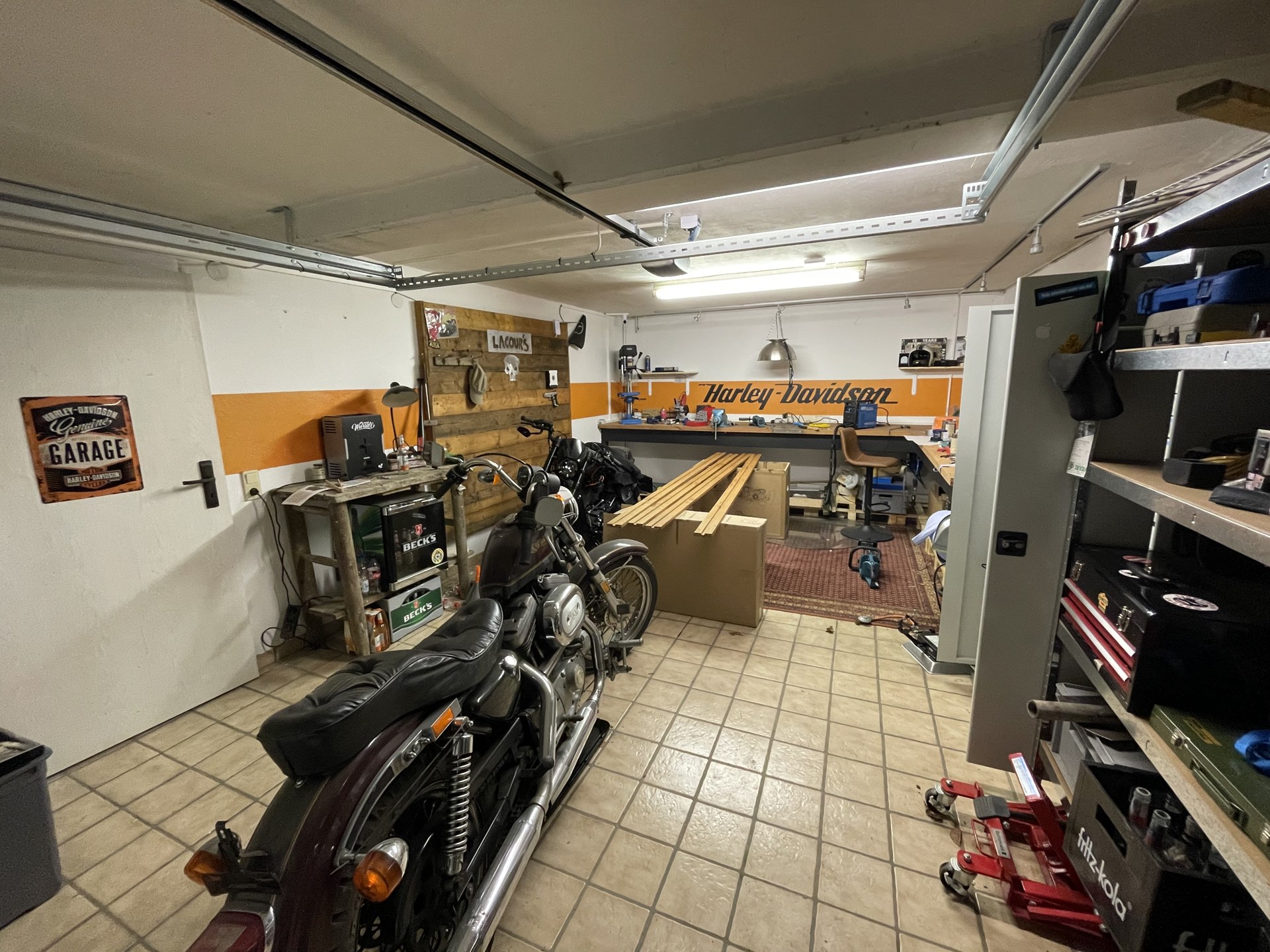 Blick durch die eingerichtete Werkstatt mit Motorrädern und Werkbänken