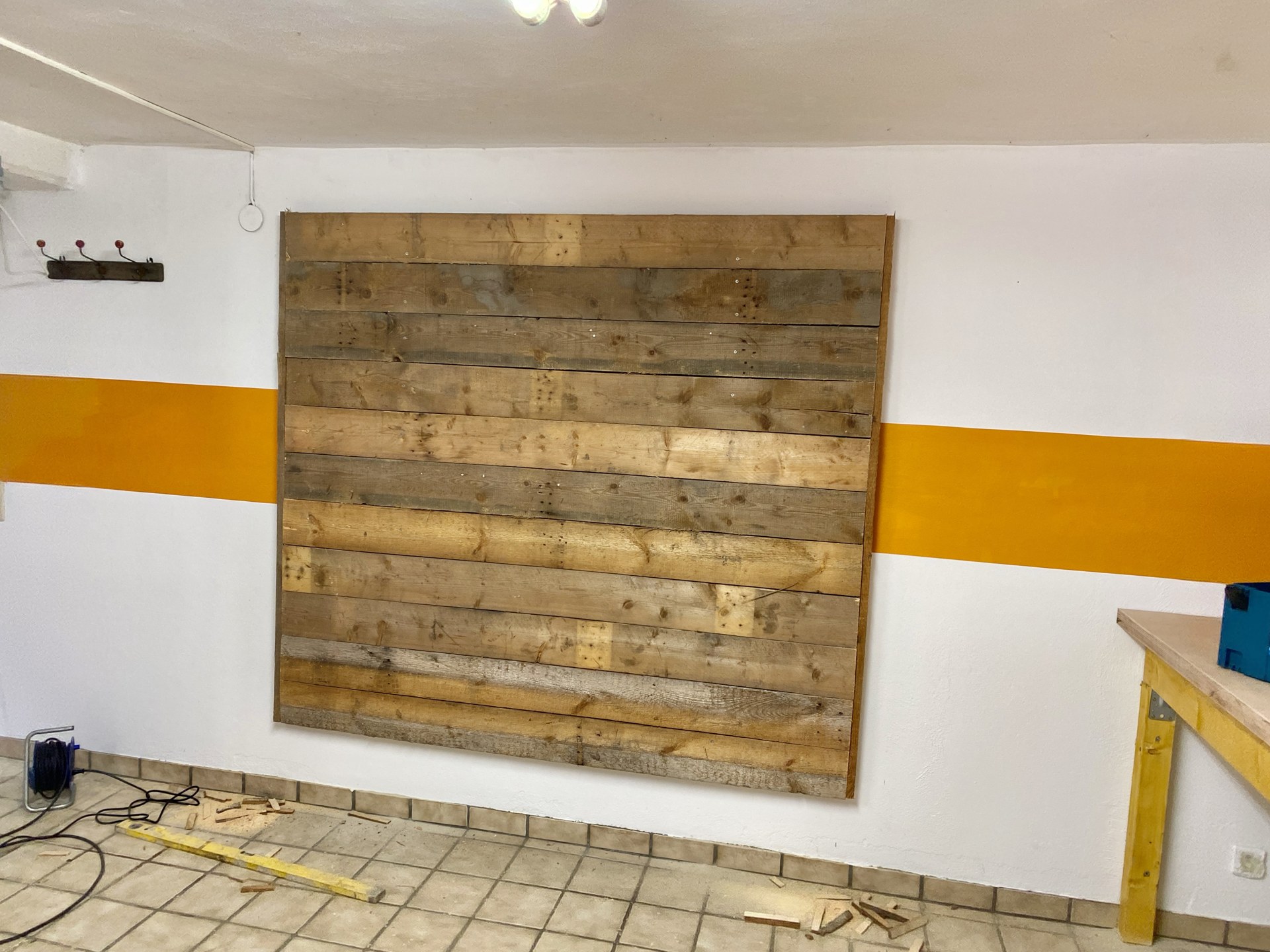 Holzwand aus Brettern neben dem orangefarbenen Wandstreifen